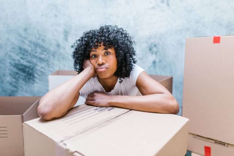 family betrayal story showing a woman surrounded by moving boxes